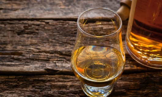 verre et bouteille de whisky sur une table en bois
