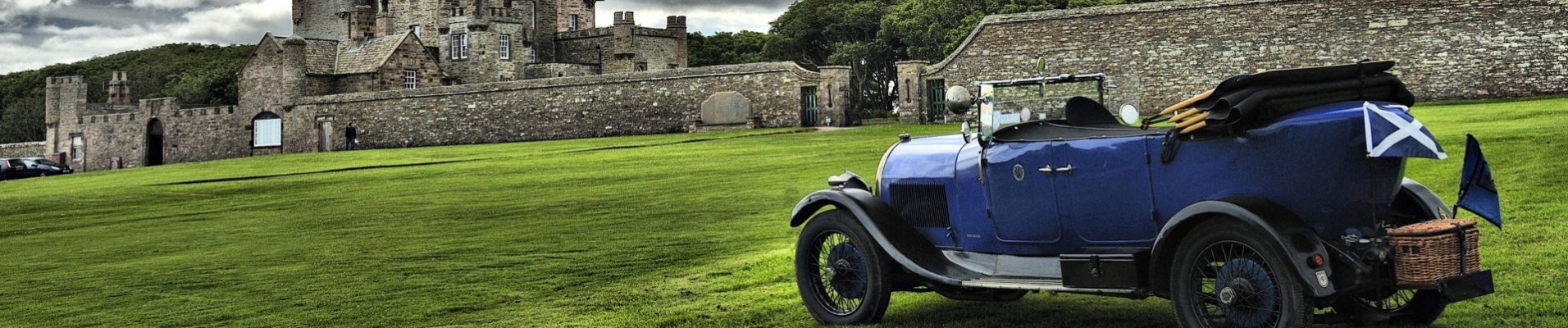 vieille voiture devant un château en Ecosse