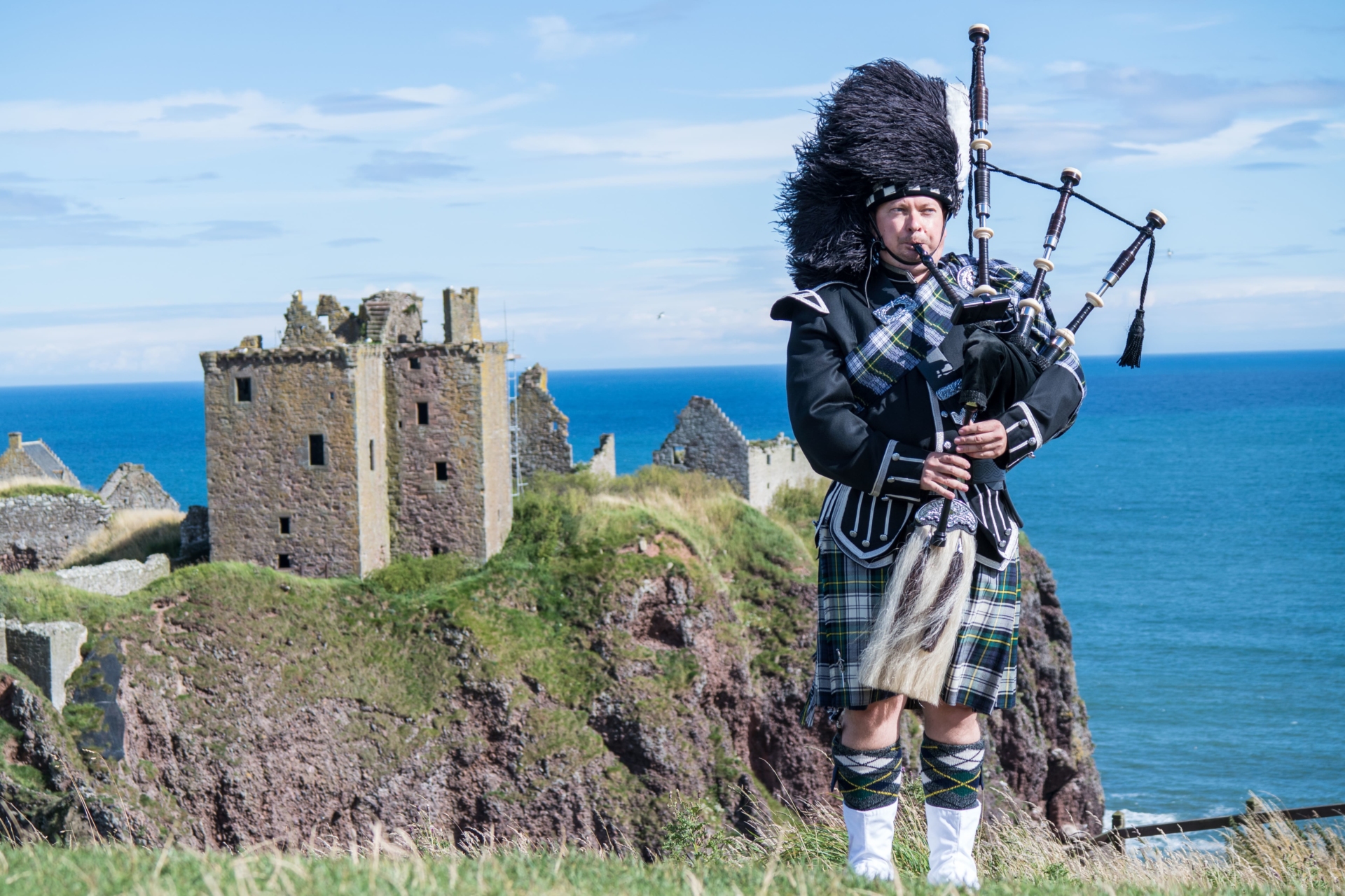 joueur de cornemuse devant le château de Dunnotar